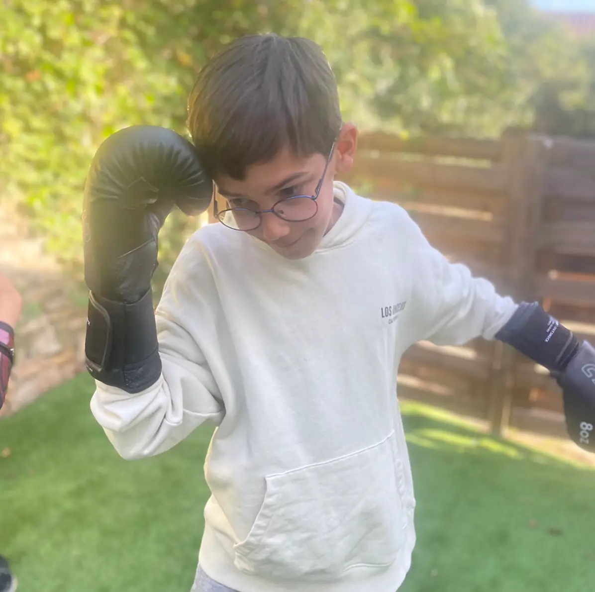 Un jeune qui apprend a donner un coup de poing avec sa garde en kung fu