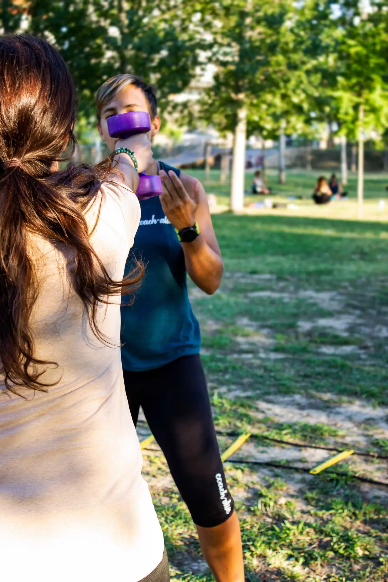 De dos, une élève en train de développer sa force des bras grâce aux haltères