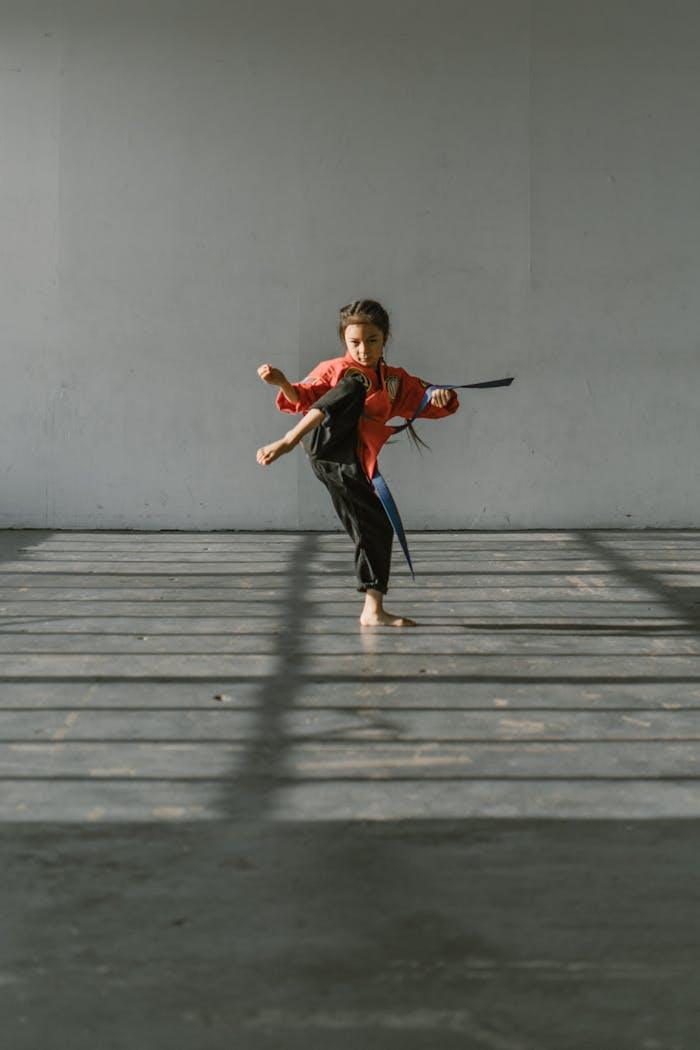 The Art of Drawing Readers In: Your attractive post title goes here Young girl practicing a high kick in martial arts studio with determination.