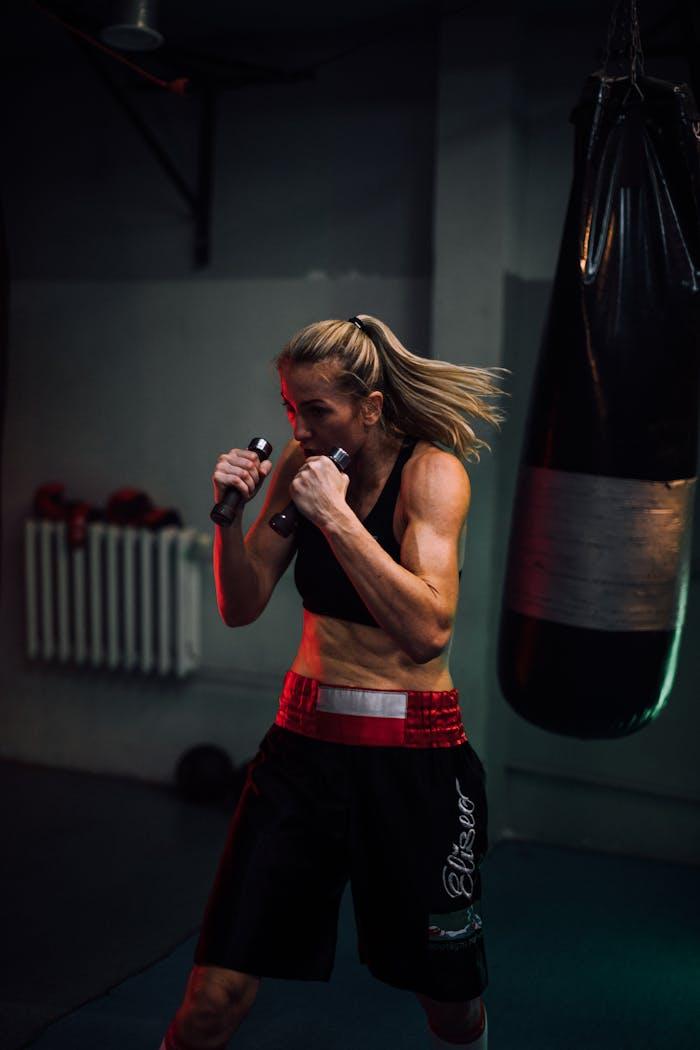 Crafting Captivating Headlines: Your awesome post title goes here Strong female boxer training indoors with a punching bag, showcasing power and focus.